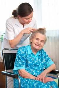 Nurse combing senior woman hair