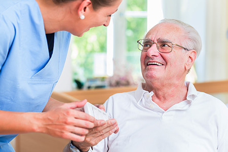 Nurse giving senior man prescription drugs