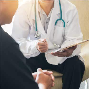 patient sitting with doctor and clipboard