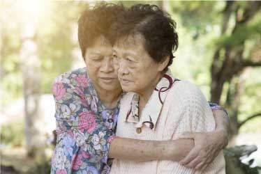 Elderly asain woman comforting a friend