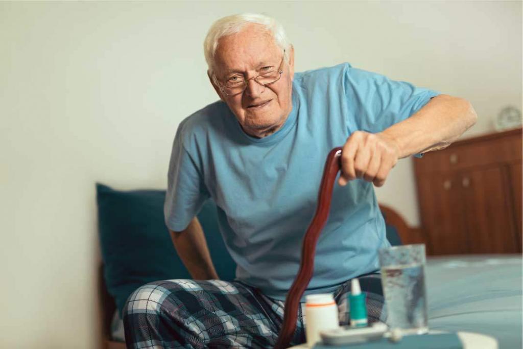 elderly man with cane sitting down