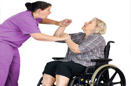 Home care nurse struggling with patient in wheelchair