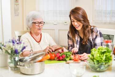 Grandma and grand daughter preparing salad