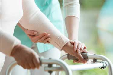 Nurse assisting an elderly woman with a walker