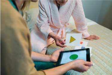 Nurse administering shape recognition test to elderly woman